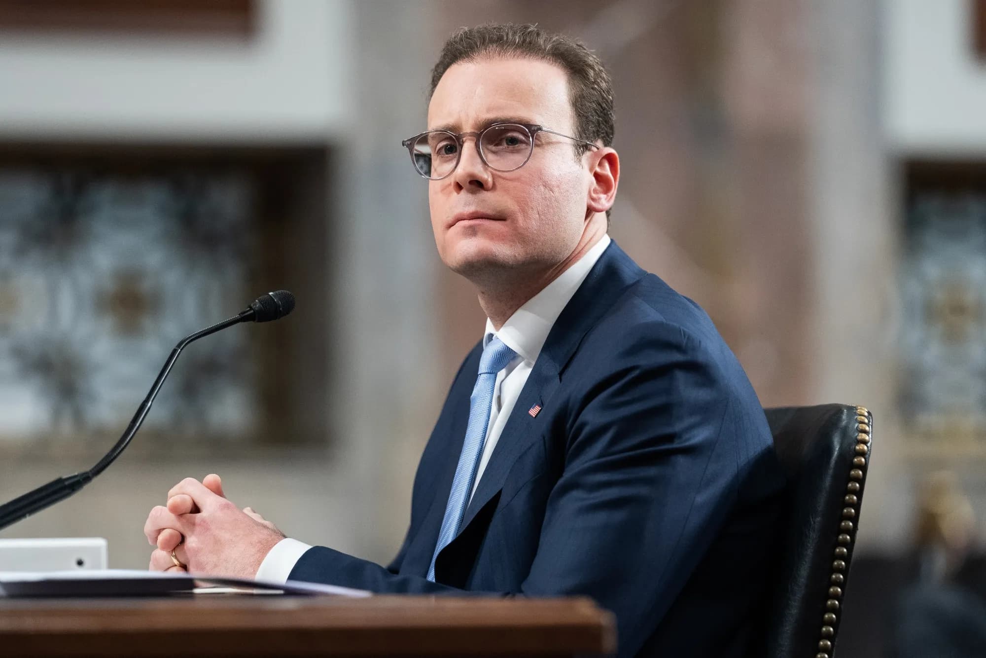 A financial regulator seated at a witness table during a congressional hearing.