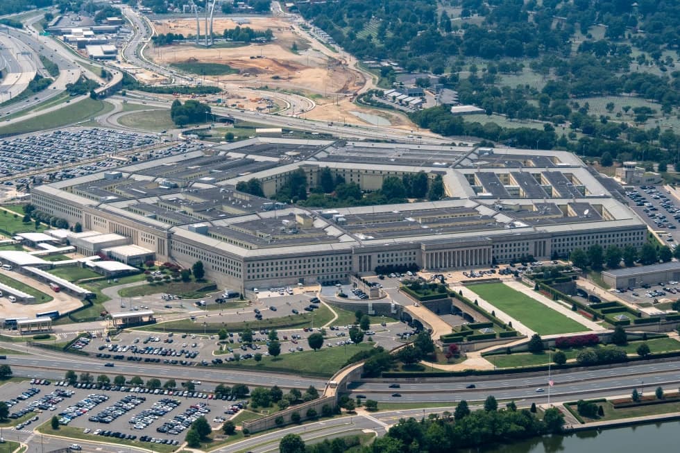 An aerial view of the Pentagon building and its surrounding parking lots and roadways.