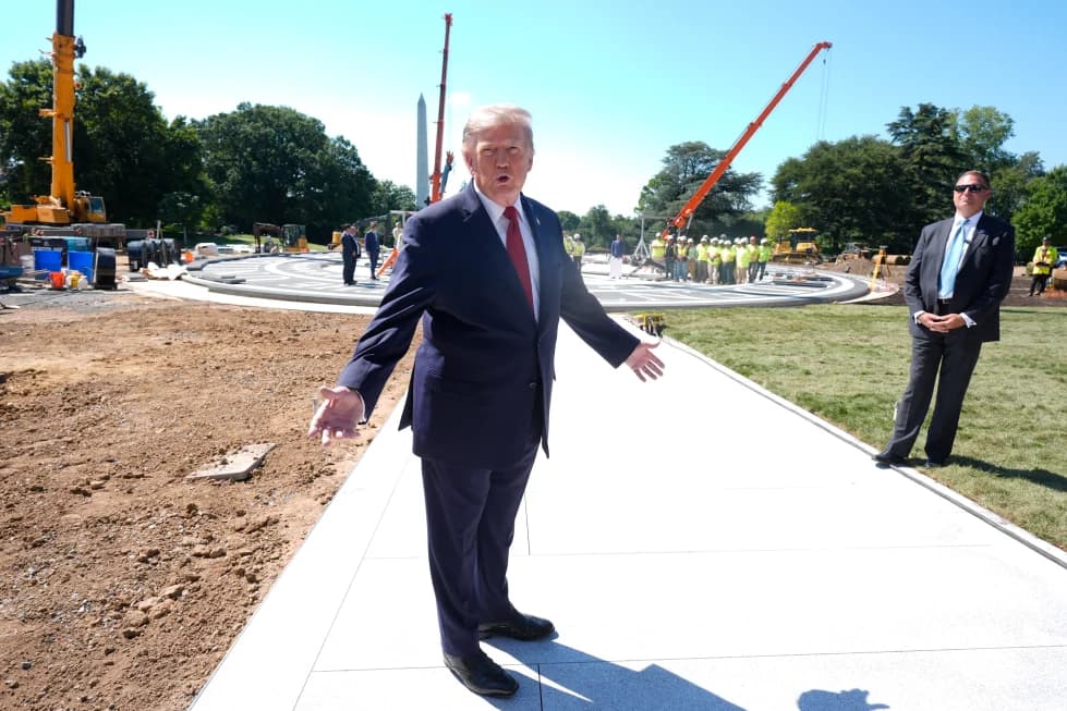 President Trump gesturing while walking past construction work on the White House grounds, with the Washington Monument visible in the background.